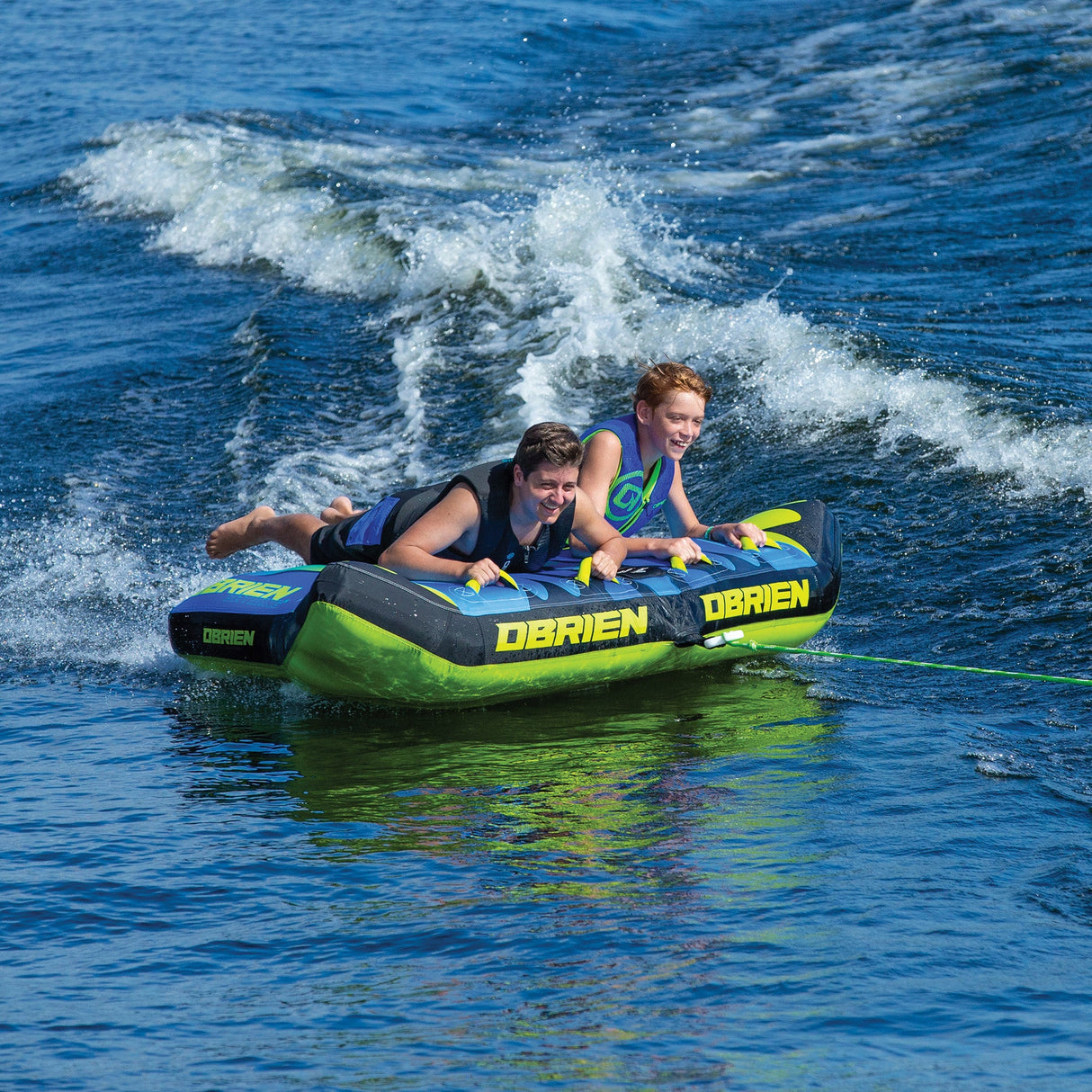 Two kids smiling, enjoying a fun ride on an inflatable OBrien Bat Wing 2 Towable Tube.