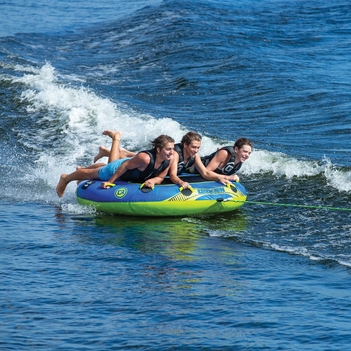 Three enjoy an OBrien Ultra Screamer Towable Tube ride with smiles and laughter.