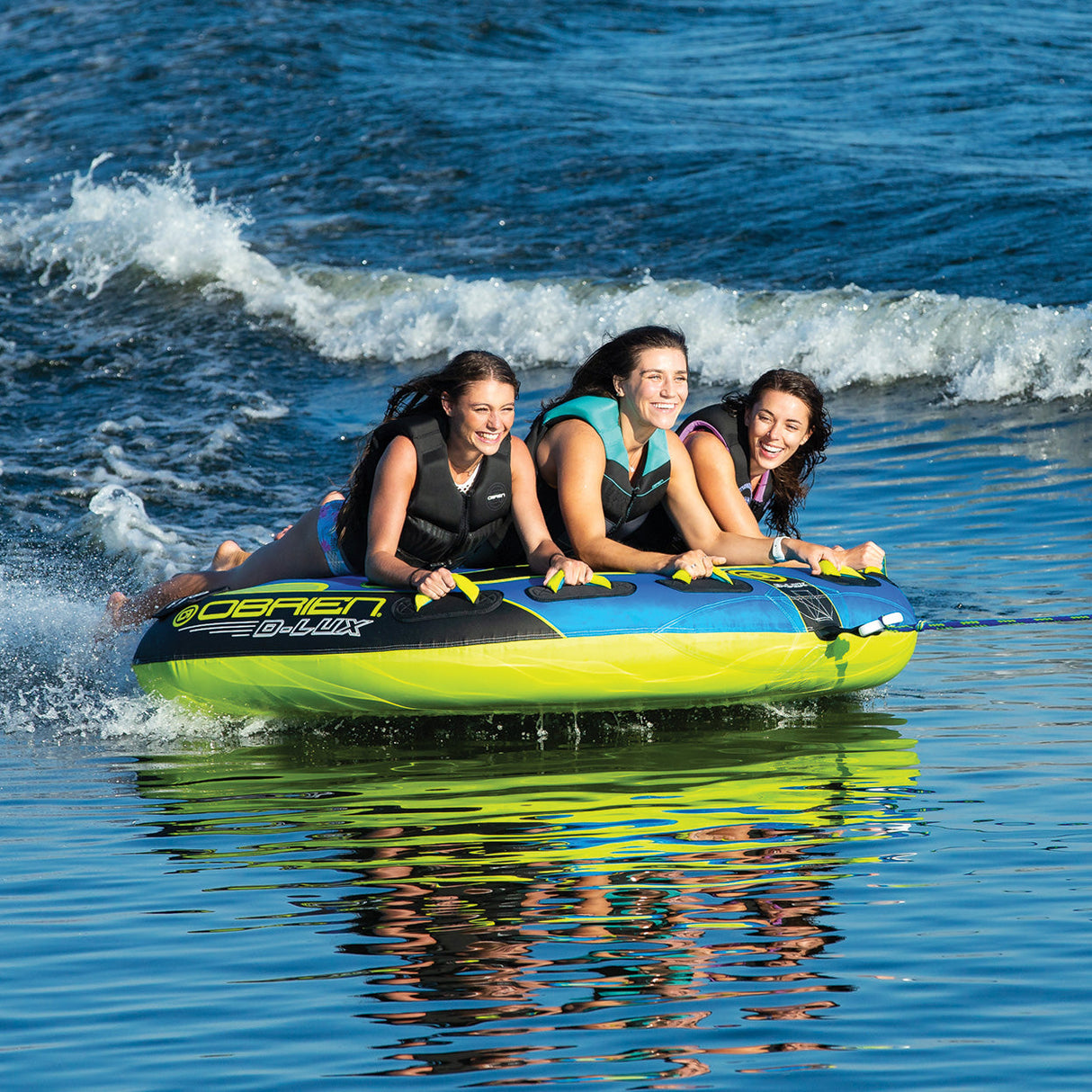 Three friends enjoy tubing on the lake with the OBrien D-Lux 3 Boat Tube.