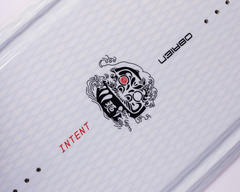 Angled close-up of O'Brien Intent Wakeboard’s black tribal-style logo with intricate red detailing.