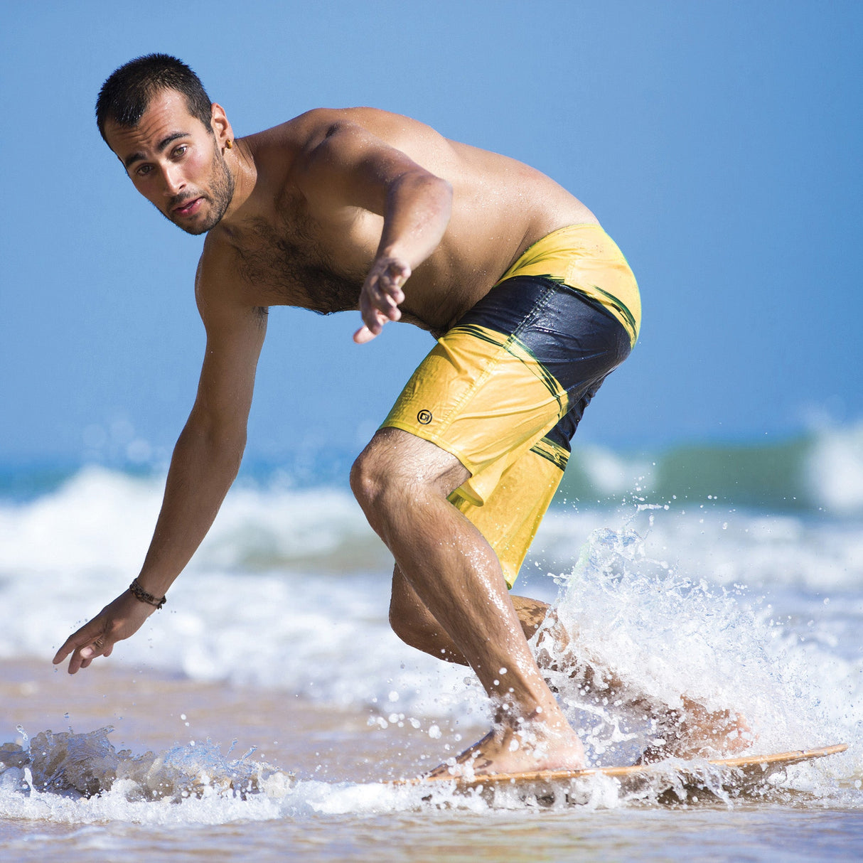 Person skimboarding at the shoreline riding the O'Brien Skimboard 35" in shallow surf.