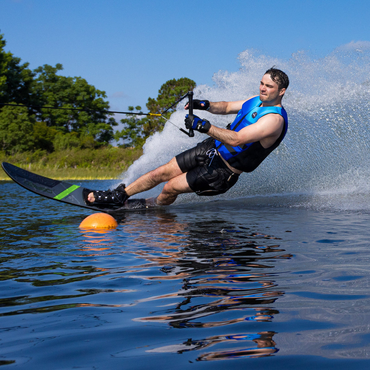 Side view of a skier navigating a buoy on the O'Brien Siege Slalom Waterski, demonstrating edge control.
