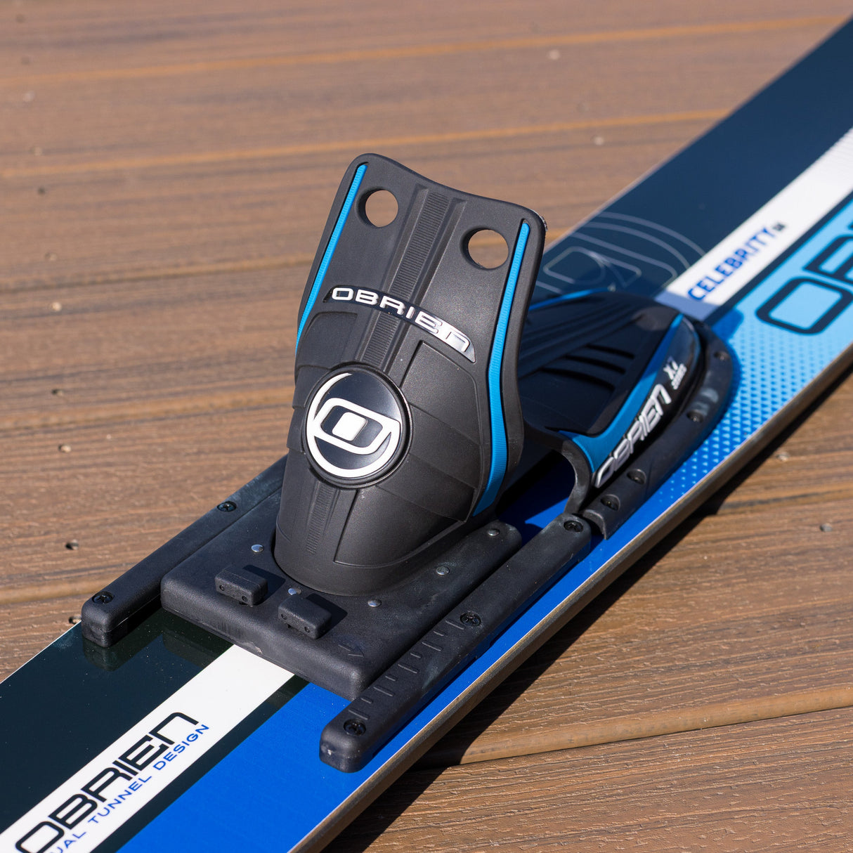 Close-up of a ski binding on a ski with 'O'Brien' branding on a wooden surface.
