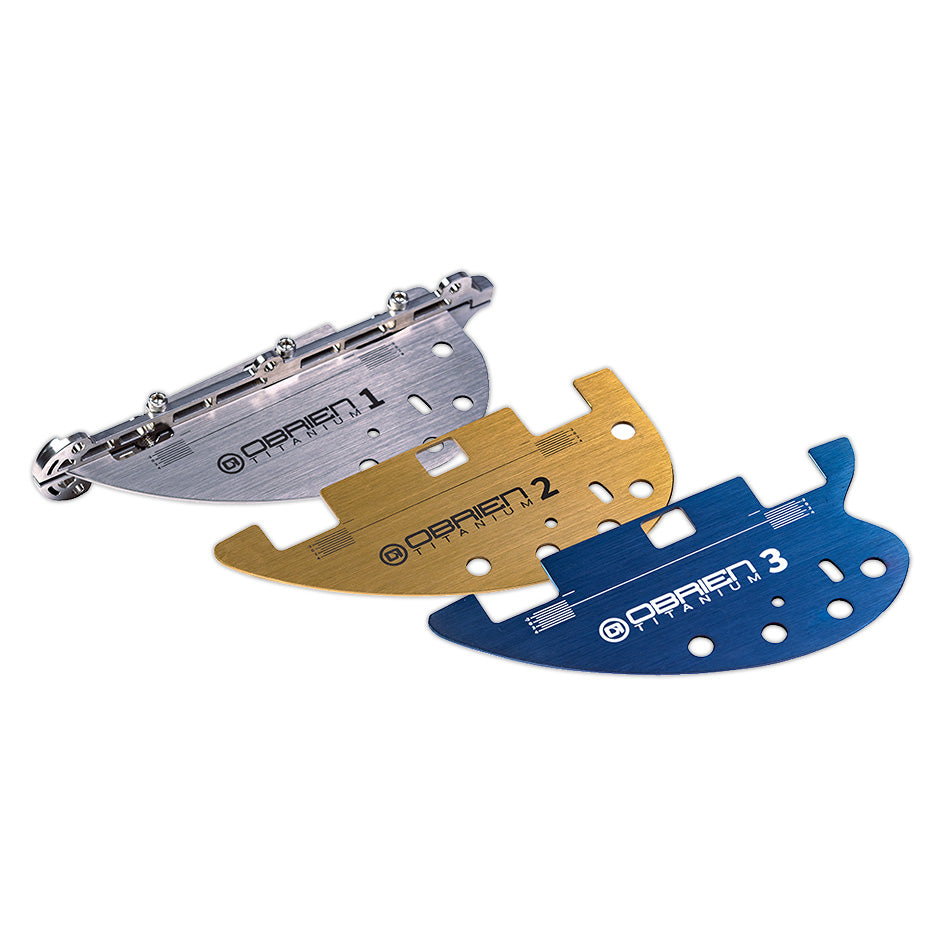 Three O'Brien GC Titanium fins in silver, gold, and blue, each labeled for precise water performance tuning.