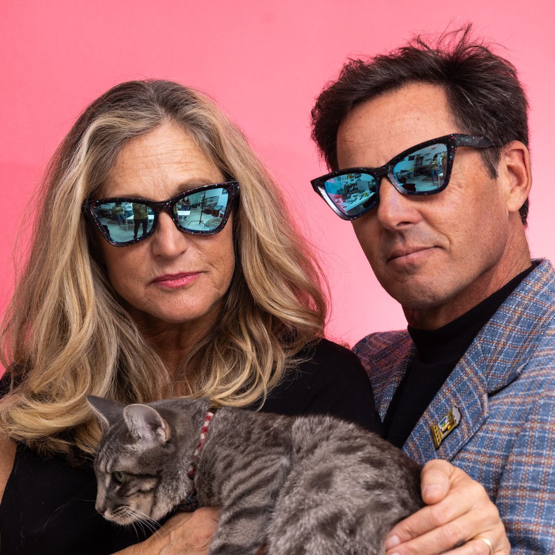 / Blue | its_not_like_I_have_anything_better_to_do.JPEG | A woman and a man wear The Midnight Clawdia with a blue lens from Pit Viper while holding a cat