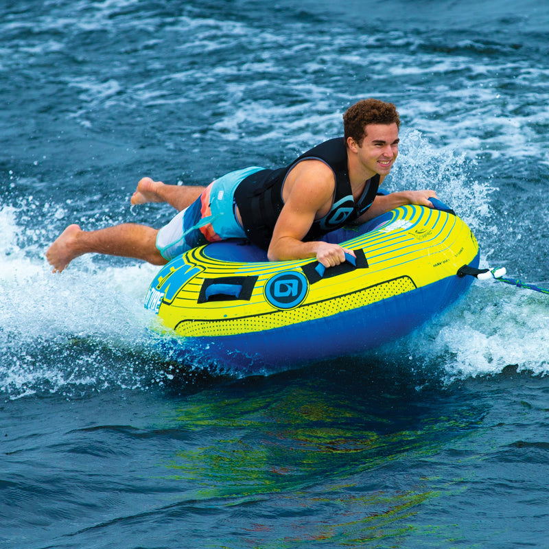 Person smiles while enjoying the OBrien LeTube Deluxe Towable Tube, wearing a life jacket.