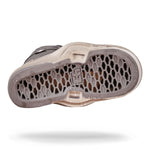 The image showcases the sole of a wakeboard binding highlighting its honeycomb base against a white backdrop.