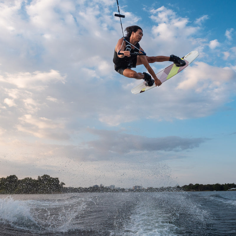 Low-angle shot of a wakeboarder executing a stylish trick on the O'Brien Clutch Wakeboard over the wake.