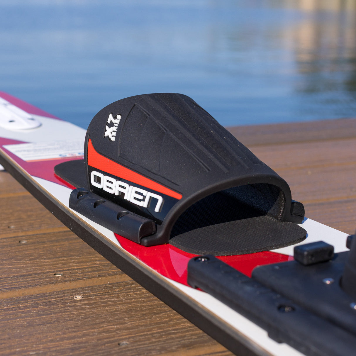 Black foot strap with 'O'Brien' branding on a waterski, with water in the background