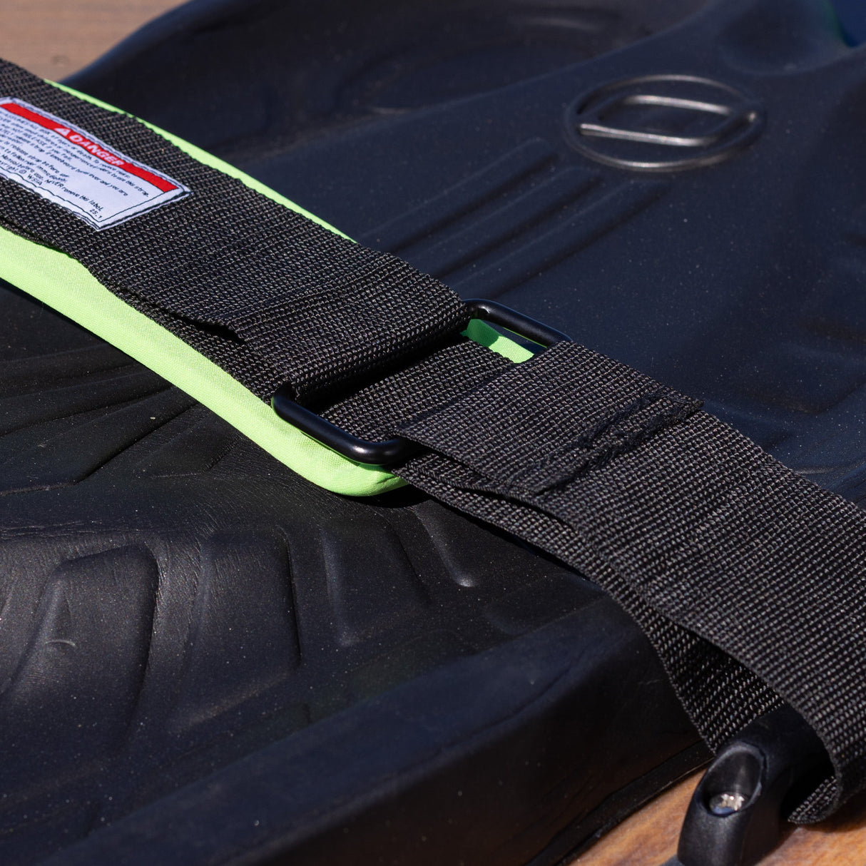 Close-up of the padded black strap with green lining on the O'Brien Enforcer Kneeboard.