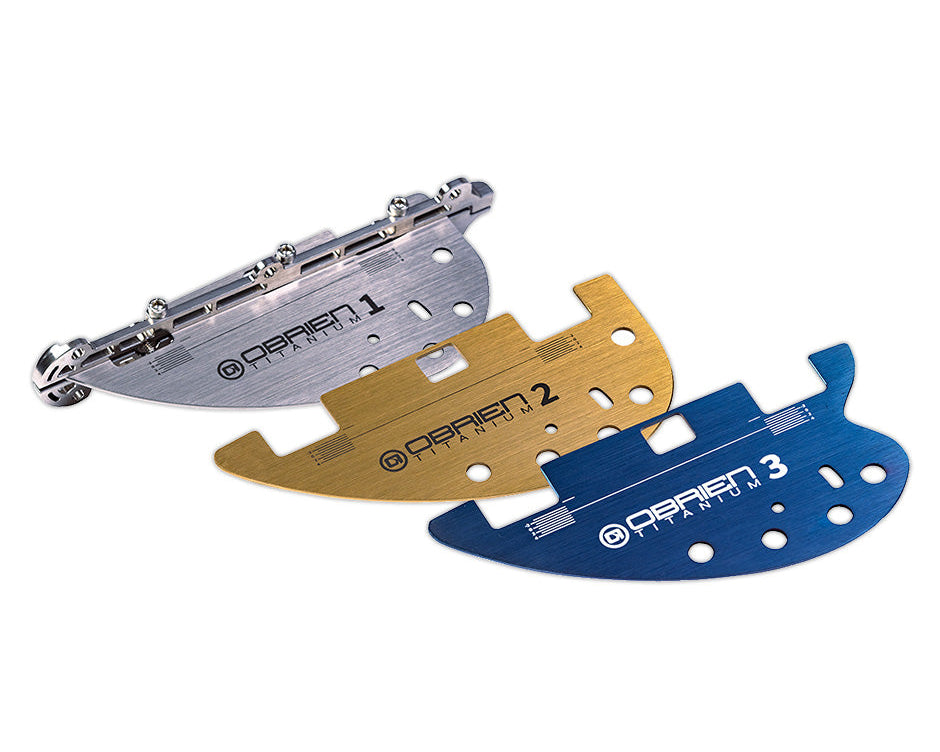 Three O'Brien GC Titanium fins in silver, gold, and blue, each labeled for precise water performance tuning.